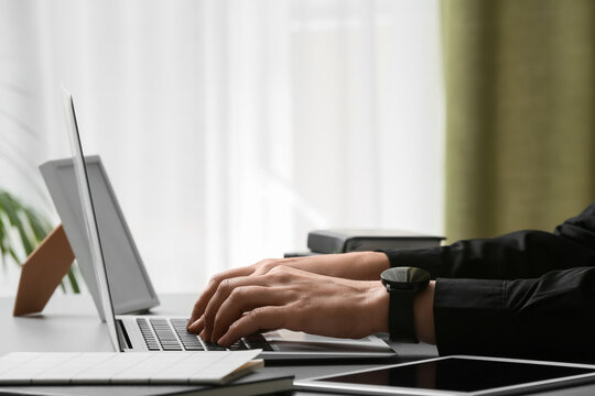 Young female programmer working with laptop in office, closeup