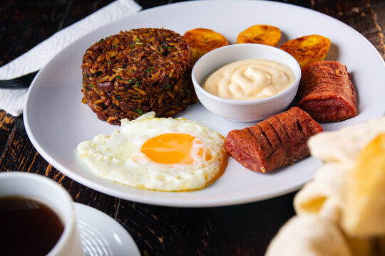 Traditional Costa Rican breakfast with gallo pinto, fried egg, natilla and coffee