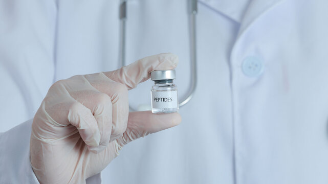 Hopeful doctor wearing glove holding peptide vial for medical therapy treatment offering scientific medicine breakthrough