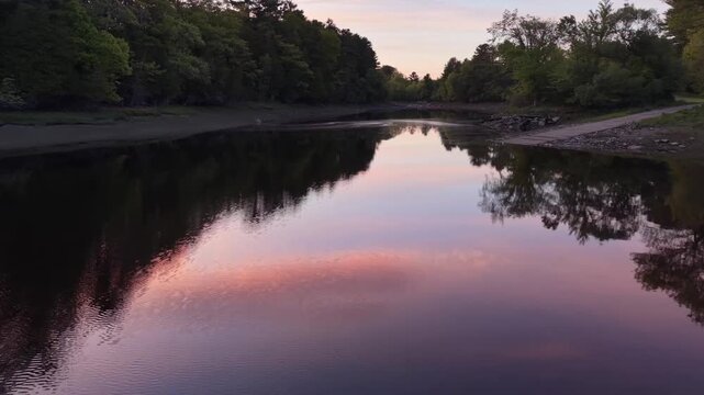 Moving slowly up the stream past the boat ramp near low tide on a calm evening at sunset in Orrington, Maine