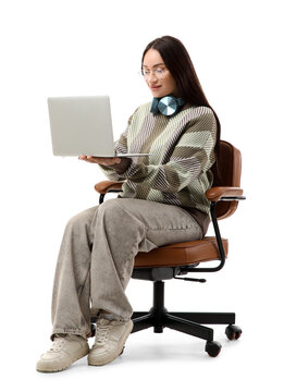 Beautiful young female programmer with laptop sitting on chair against white background