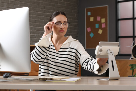 Beautiful young female programmer working with tablet computer in modern office