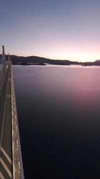 FPV drone perspective sweeping past the massive pillars of the Peljeski Most landmark. High-angle dynamic footage of contemporary civil engineering in the Balkans.