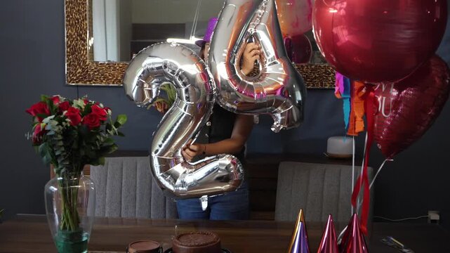 Young woman happily celebrating her 24th birthday at home