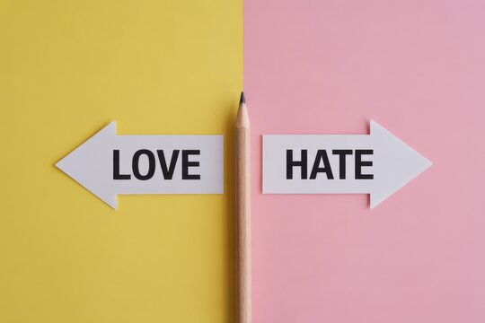 A conceptual photo of a pencil pointing towards love and hate