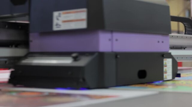Large format printer prints colorful poster, demonstrating efficiency and precision of modern printing technology.