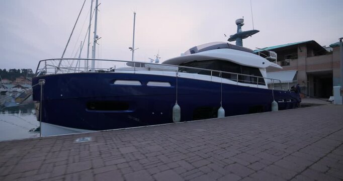 Yacht with a blue hull moored at a dock in the harbor