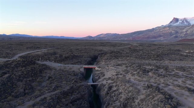 Drone Aerial Establishing of Volcanic Canyon in La Payunia Reserve Mendoza Argentina with Andes Mountains Sunset Background