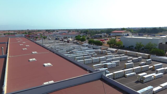 Large-scale industrial logistics depot filled with rows of stored construction materials and shipping pallets, capturing the scale of a busy distribution and warehouse facility.