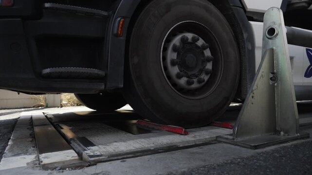 Close up of large truck tire on brake tester rollers, industrial facility, France.