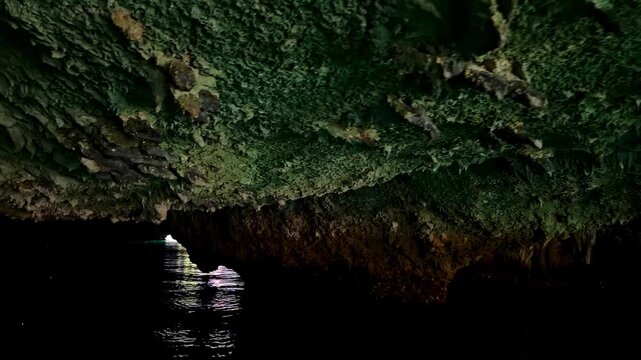 Boat Navigating a darg sea cave in Sohoton Cove National Park in the Philippines