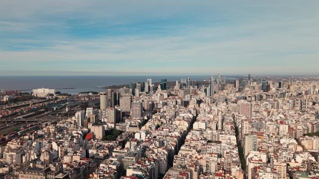 Buenos Aires skyline rises above dense urban blocks and Puerto Madero waterfront along the R&iacute;o de la Plata, showcasing modern towers, historic districts and metropolitan development, forward flyover