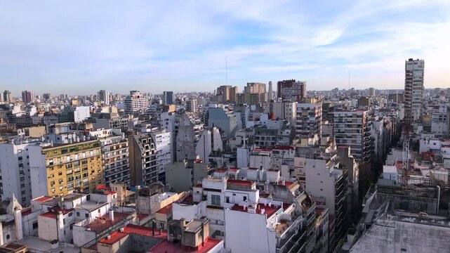 Dense residential towers, apartment blocks and commercial buildings fill central Buenos Aires, Argentina, revealing compact urban fabric and high-density development, drone oblique slide shot.