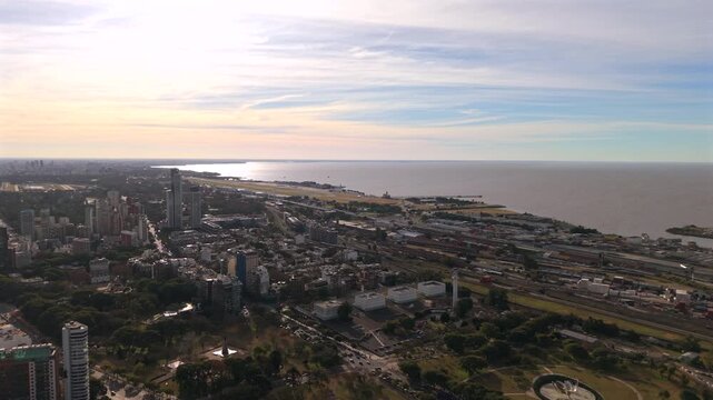 Reserva Ecol&oacute;gica Costanera Sur borders the R&iacute;o de la Plata in Buenos Aires, Argentina, alongside Puerto Madero, rail infrastructure and waterfront developments, drone slow oblique forward flyover