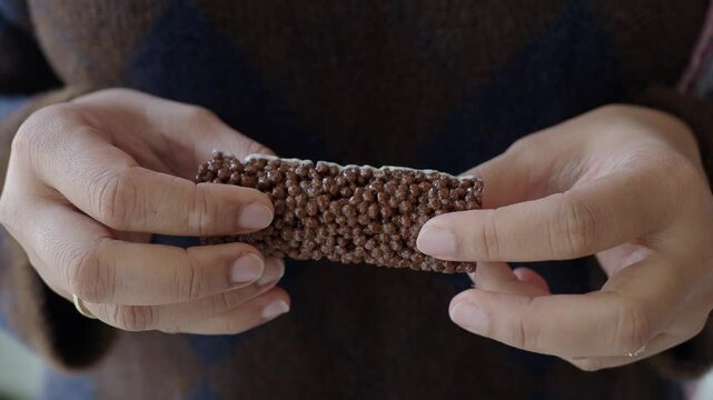 A person holds a chocolate bar in their hands.