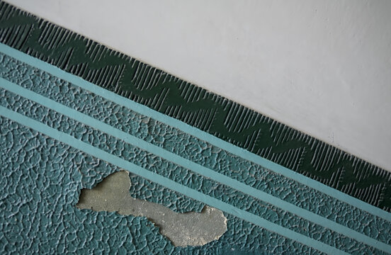 Damaged vintage painted wall pattern with peeling paint.