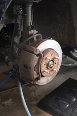 Fototapeta premium Close-up. Car brake disc and caliper during repair.