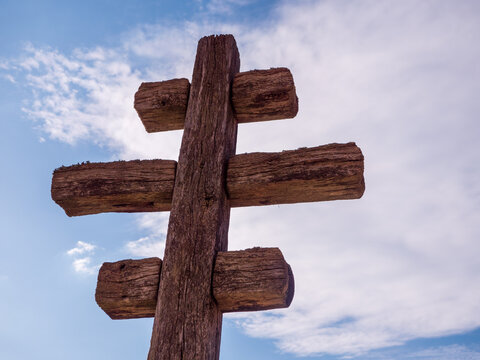 Traditional wooden patriarchal cross against a blue sky, symbolizing Christian faith, spirituality, Saints Cyril and Methodius, cultural heritage and Slovak identity.