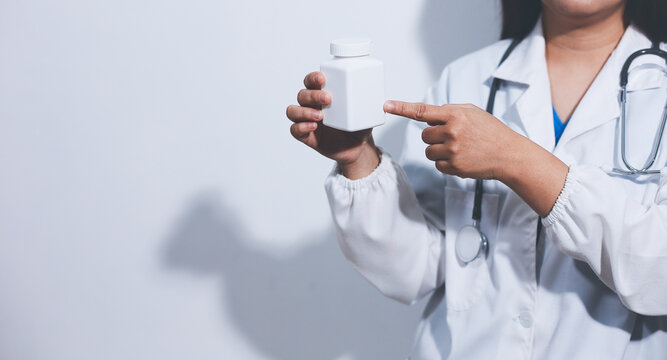 The pharmacist or doctor holding medication or medicine for treatment. Anti biotic pill in the vial.