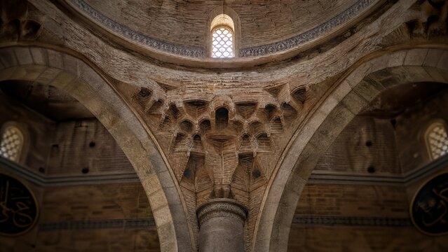 A stone squinch arch supporting a dome inside an ancient mosque.