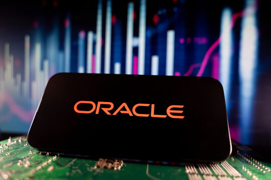 Close up of Oracle logo on smartphone screen with technology and financial chart background. Toronto, Canada - June 11, 2026.