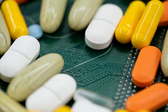 Close up of pills on circuit board with health technology concept.