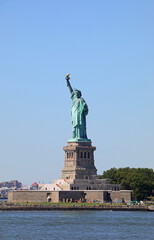 Fototapeta premium iconic statue of liberty symbol of freedom with raised torch representing american democracy viewed from the sea