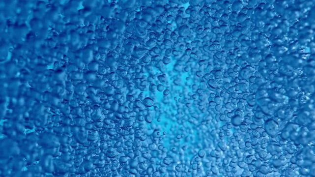 A mesmerizing underwater shot reveals myriad blue bubbles rising gently, creating a dynamic and serene background, a soothing aquatic visual experience.