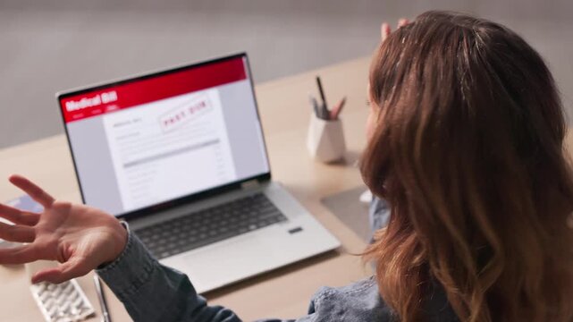 Worried Woman Reads Hospital Bill On Laptop