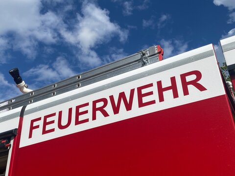 Nahaufnahme eines Feuerwehrfahrzeugs mit markantem Feuerwehr-Schriftzug. Symboltr&auml;chtiges Motiv f&uuml;r Rettungsdienst, Brandschutz, Einsatzkr&auml;fte, Sicherheit und Katastrophenschutz. Echtfoto.