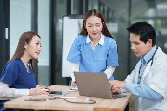 Medical Team Discussing Patient Case on Laptop in Hospital