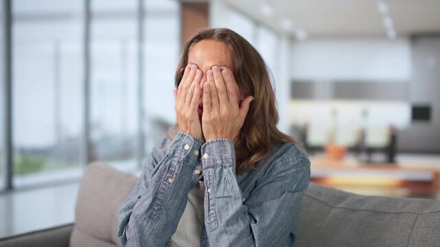 Older Woman At Home Rubbing Tired Eyes Feeling Migraine