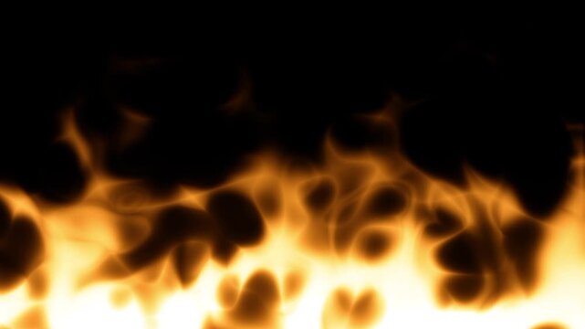 A ground level view of blazing fire with bright orange and yellow flames spreading horizontally close to the surface in a dramatic scene