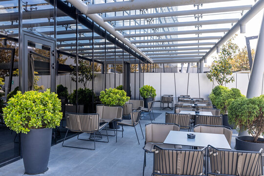 Modern outdoor restaurant terrace with stylish chairs tables and green plants