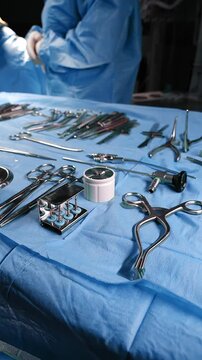Preparation for the surgery. Surgery tools. Multiple surgery tools on the table in operating room. Scrub nurse hands in rubber gloves. Modern medical concept.