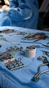 Preparation for the surgery. Surgery tools. Multiple surgery tools on the table in operating room. Scrub nurse hands in rubber gloves. Modern medical concept.