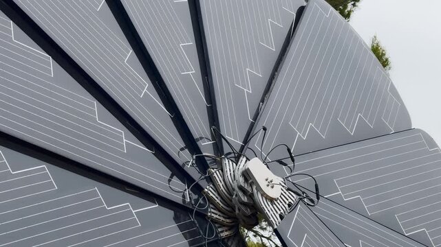 Close-up of a foldable solar panel array with cables and control unit, showing portable renewable energy technology and outdoor power setup.