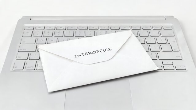 Envelope Marked &ldquo;INTEROFFICE&rdquo; Resting on White Computer Keyboard