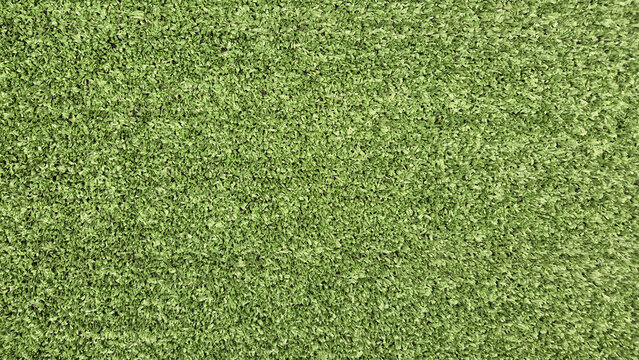 A top-down, full-frame shot showcases a dense, uniform texture of bright green artificial turf or synthetic grass blades.