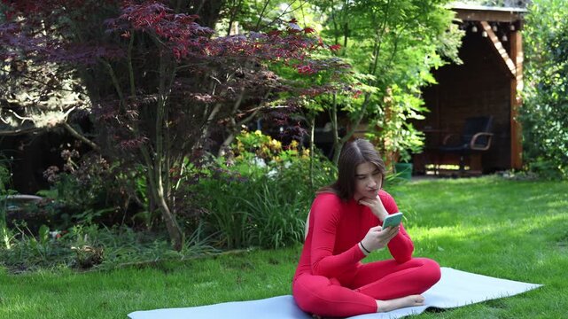 Woman checks her smartphone during a yoga session showing how digital distractions can interrupt self care mindfulness and the ability to stay present in the moment