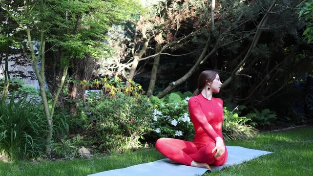 Woman performs a seated yoga twist in a garden symbolizing a conscious choice to step away from distractions improve focus and reconnect with personal priorities
