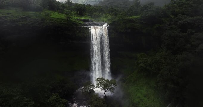An awe-inspiring aerial view showcasing the raw, untamed beauty of a majestic waterfall in Bhandardara, Maharashtra, during peak monsoon season.
