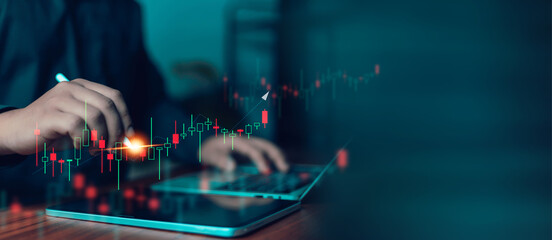 Stock market trading and financial investment concept featuring a professional analyzing candlestick charts on tablet and laptop, monitoring market trends, price movement, technical analysis, digital