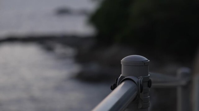 海岸沿いのガードレールと背景の美しい海のボケ 4K（クローズアップ・固定撮影）
