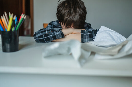 Frustrated student hiding face while studying at home