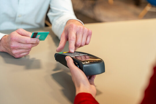Customer paying cashier at terminal with card