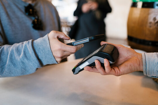 Customer paying through contactless payment by using smart phone at a bar
