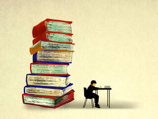 Stack of oversized books behind boy studying at desk
