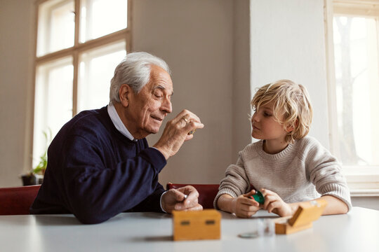 Watchmaker and his grandson examining watch together