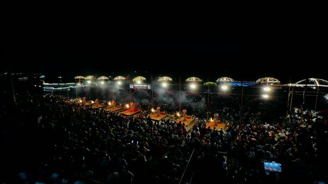 Benares, India, April 5, 2026 ceremony on the banks of the Ganges River in Varanasi. A back shot of a Pujari or Brahmin (Hindu Priest) holding fire lamps/ lantern/ Diyas Performing Ganga Pooja 